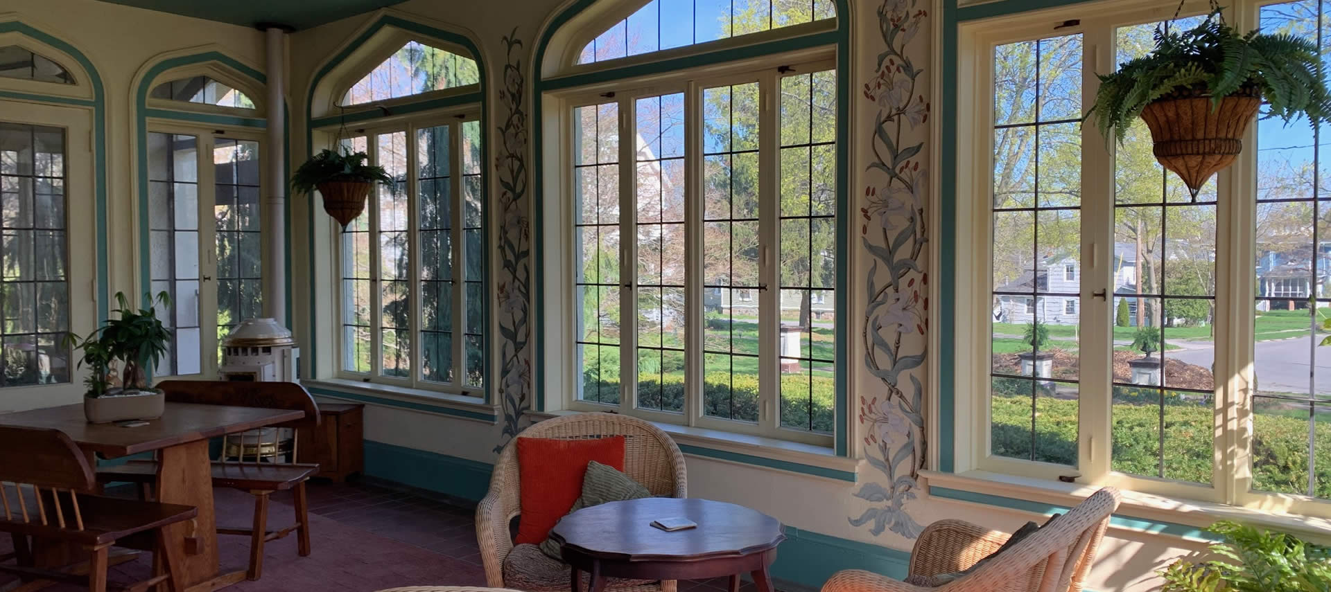 Custom painted sun room with many unique windows and tables and chairs.